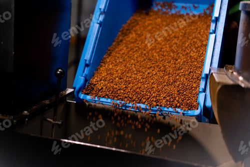 Preview: close-up at coffee factory coffee is poured from a blue container into a roasting machine