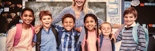 Preview: Happy teacher standing with schoolkids in classroom