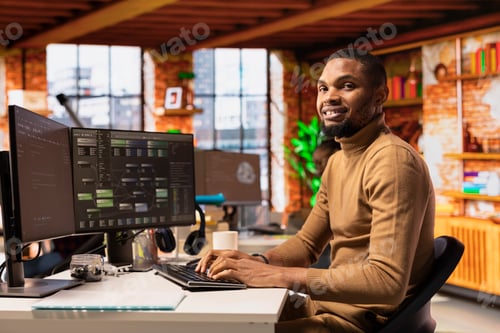 Preview: Portrait of cheerful IT technician using PC in innovative startup office