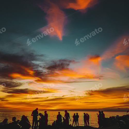 Preview: Silhouettes of a group of young friends having fun on the beach at sunset