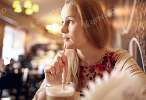 Preview: Girl is looking through the window in cafe