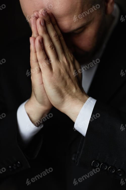 Preview: Man in black suit praying