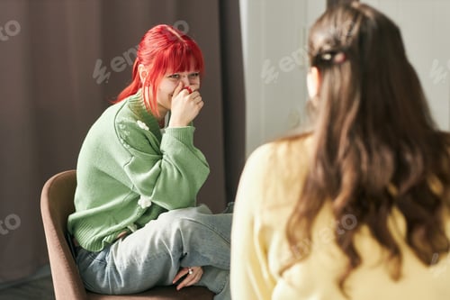 Preview: Smiling Woman with Red Hair Sitting on Chair Looking Away