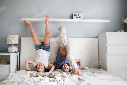 Dos niños saltan boca abajo en una cama grande