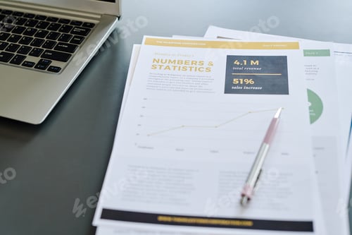 Preview: Several financial documents with data, pen and laptop keyboard