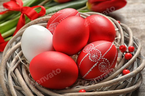 Preview: Wicker nest with painted Easter eggs on table, closeup