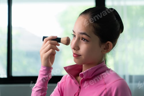 Preview: A girl ballet student in pink tracksuit use blush to put on makeup before performing ballet