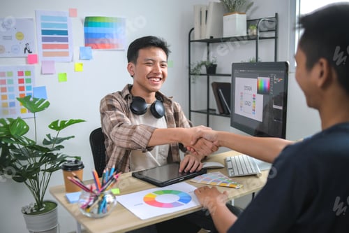 Preview: Two Young Creative Professionals Reviewing Digital Design Work and Making Agreement