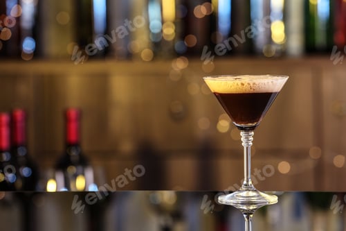 Preview: Glass of delicious Espresso Martini on bar counter, space for text. Alcohol cocktail