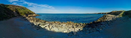Preview: Panorama of a beach with sand and stones near the Black Sea under sunset light in Bulgaria