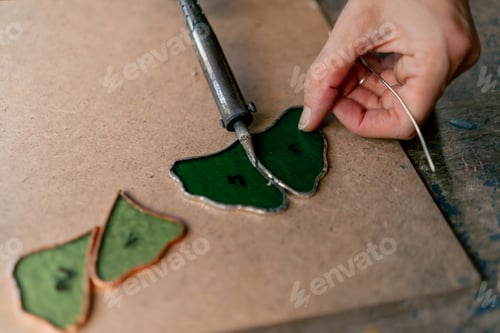 Preview: close up in a large green workshop on a woman with green hair creates decorative flowers working