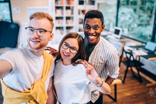 Preview: Optimistic diverse coworkers gesturing during selfie