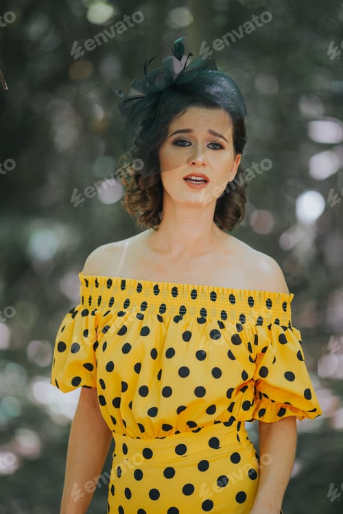 Preview: Young Caucasian female performing for music video in a yellow and black dotted dress and a hairband