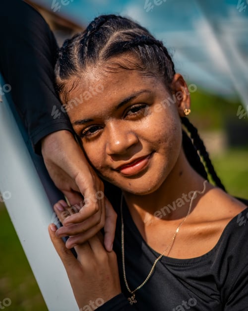 Visualização: Vertical de uma bela jovem com uma camisa preta posando ao ar livre