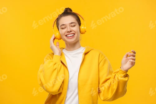 Preview: Young happy female dancing to sounds of favorite music in wireless headphones