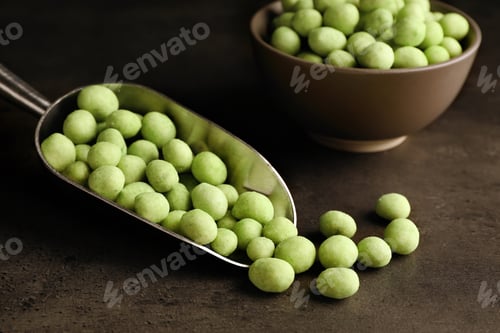 Preview: Tasty wasabi coated peanuts on grey table, closeup