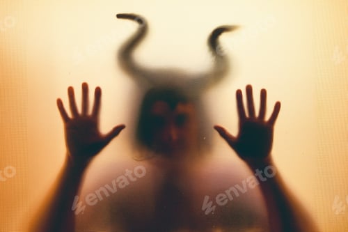 Preview: Horror, halloween background - Shadowy figure with horns behind the glass