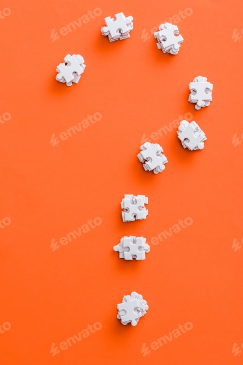 Preview: top view of question mark shape with white puzzle pieces on orange