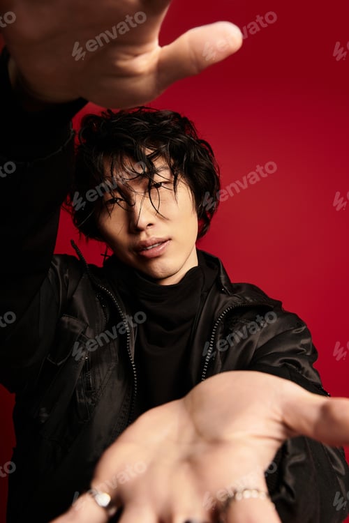 Preview: Reaching for you, a stylish asian man in a studio setting