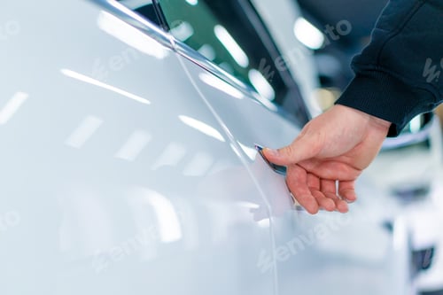Preview: A man opens the door of his luxury white car after detailing and dry cleaning at a car service