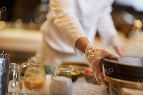 Preview: Chef in gloves moving objects on kitchen table