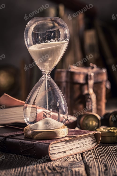 Preview: Aged hourglass and journal as a journey memories concept.