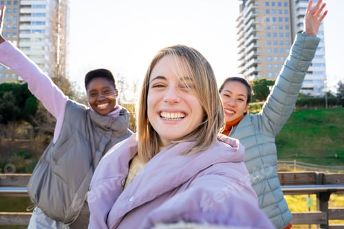 Preview: Three diverse girls taking a selfie portrait with smartphone. Friendship multi-ethnic real people.