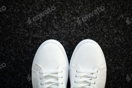 Preview: Pair of new stylish white sneakers on floor at home