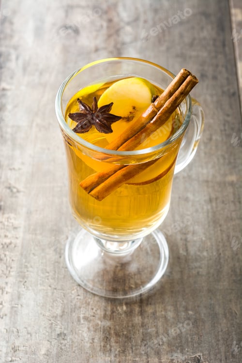 Preview: Hot apple cider with cinnamon sticks and star anise on wooden table