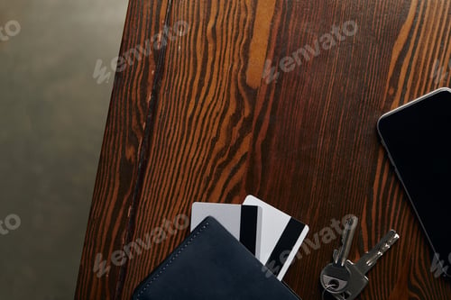 Preview: top view of credit cards, smartphone, keys and wallet on wooden surface