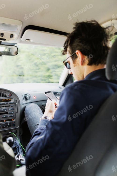 Preview: Man using smart phone in car