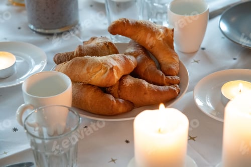 Preview: Table with a white tablecloth, plate of croissants, and glasses