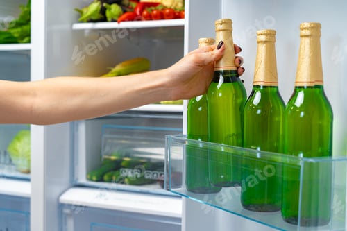 Preview: Female hand taking bottle of beer from a fridge