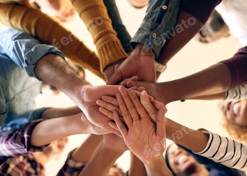 Preview: Joining their strengths in unity. Low angle shot of a group of people joining their hands together.