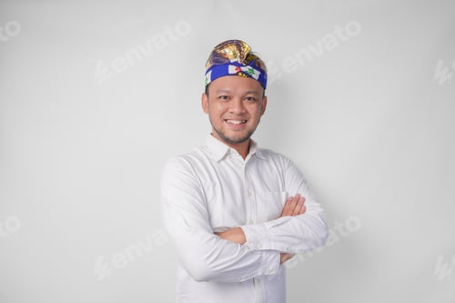 Preview: Portrait of a Balinese wearing traditional headdress called udeng posing with a crossed arms.