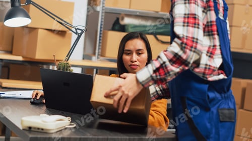 Preview: Female owner working in wheelchair at warehouse