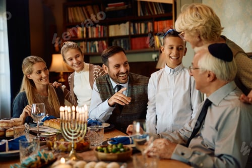 Preview: Happy Jewish extended family enjoying while gathering on Hanukkah at dining table.