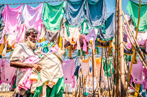 Preview: Old man hanging laundry outdoors in the sun