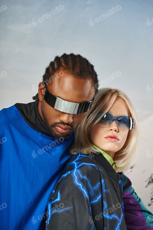 Preview: close up of stylish couple in vibrant sunglasses hugging and looking at camera, winter concept