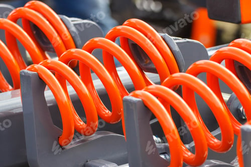 Preview: Hard orange spring made of steel. Part of big industrial or agricultural machine