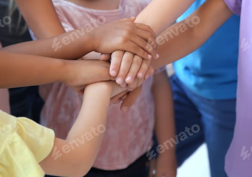 Preview: Little children putting their hands together, indoors. Unity concept