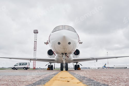 Preview: Front view. Turboprop aircraft parked on the runway at daytime