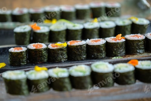 Preview: Sushi rolls with salmon on trays placed on wooden table