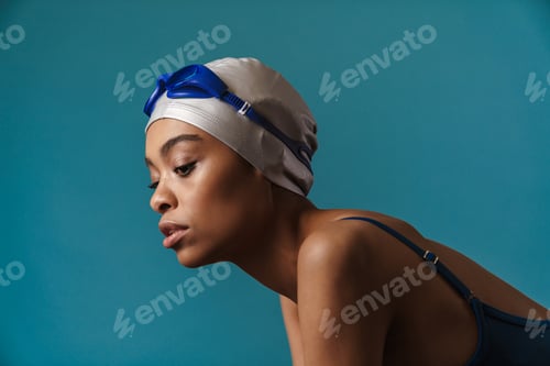 Preview: Young black swimmer in goggles posing and looking downward