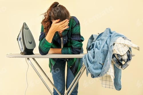 Preview: Tired woman bent over an ironing board