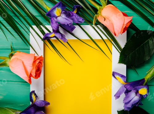 Preview: top view of dark purple and coral color iris and roses flowers and palm leaf with a frame