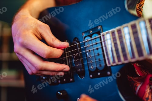 Preview: Close up of male hand playing electric guitar in the dark