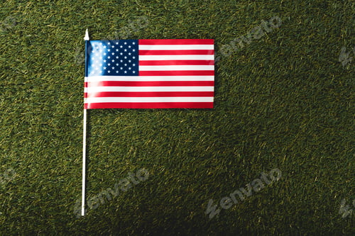 Preview: top view of american flag with stars and stripes on grass