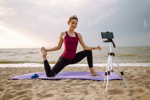 Preview: Online training. Sporty woman yoga coach records video online training yoga on the beach. Sport.