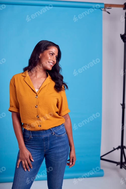 Preview: Portrait Of Mature Female Model Posing For Photographer Against Background On Studio Fashion Shoot